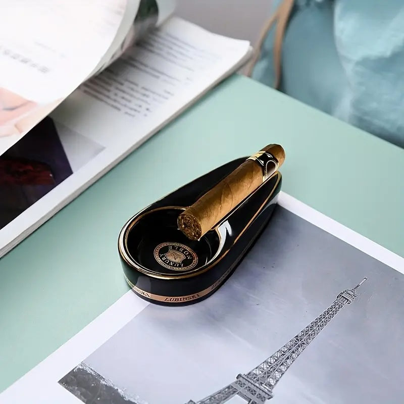 Cigar in a black humidor on top of a magazine with the Eiffel Tower illustration.