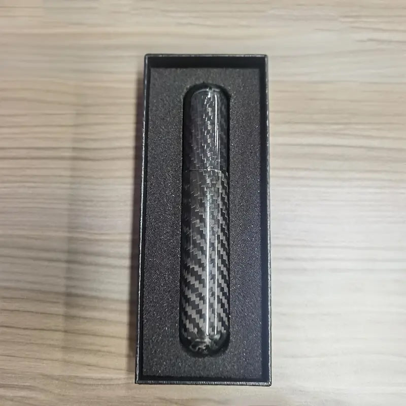 Carbon fiber pen in a black box on a wooden surface