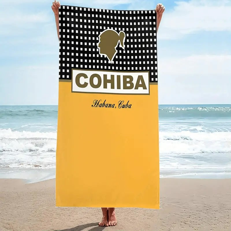 Towel with Cohiba branding held by a person on a beach