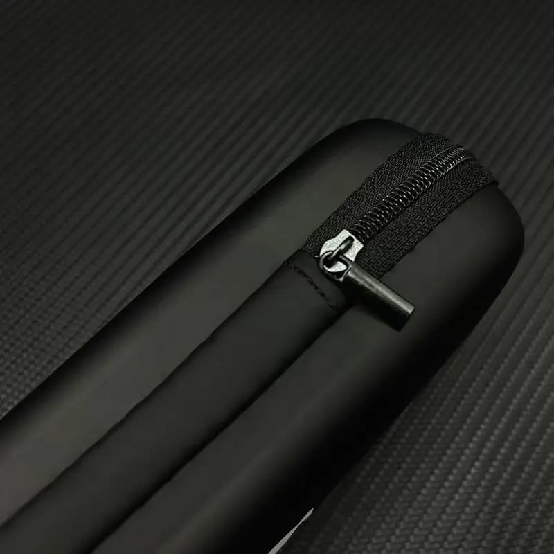 Close-up of a black suitcase with a zipper on a textured black background