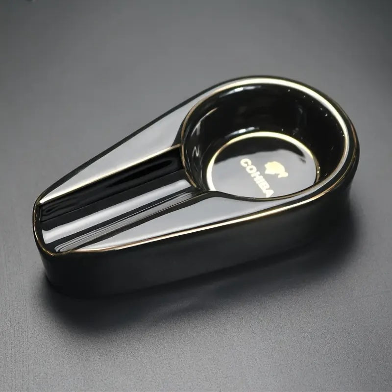 Black ceramic spoon rest with a spoon on a gray background