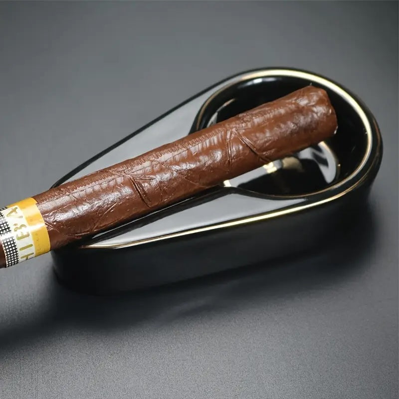 Cigar in a metal ashtray on a dark gray background