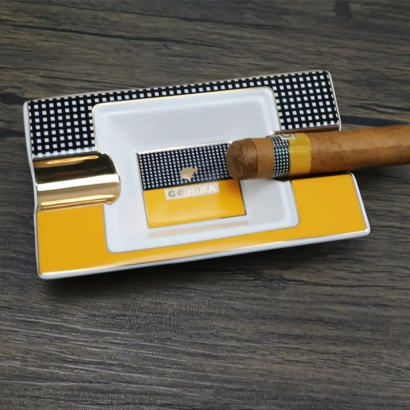 Cigar and lighter on a yellow and white ashtray with a checkered lid on a wooden surface