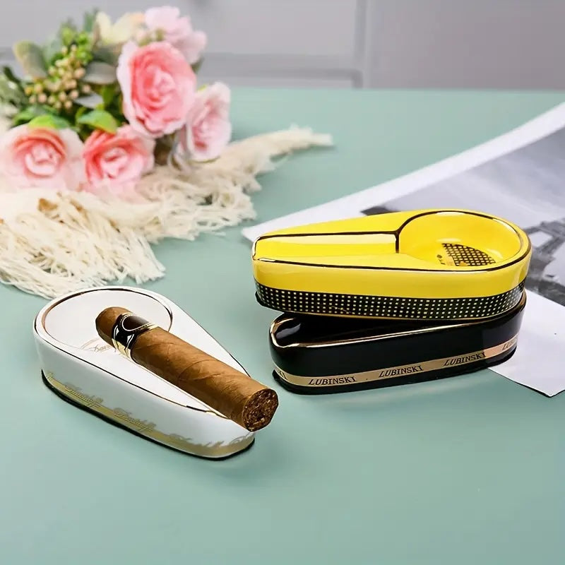 Cigar humidor with a cigar on a light blue surface with flowers in the background