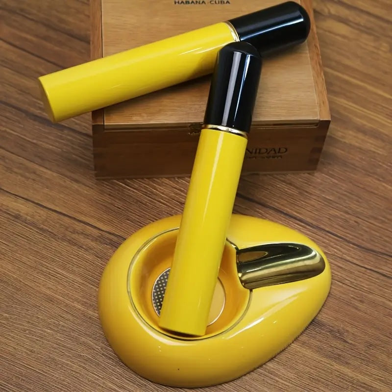 Yellow cigar cutter with black handle on a wooden surface